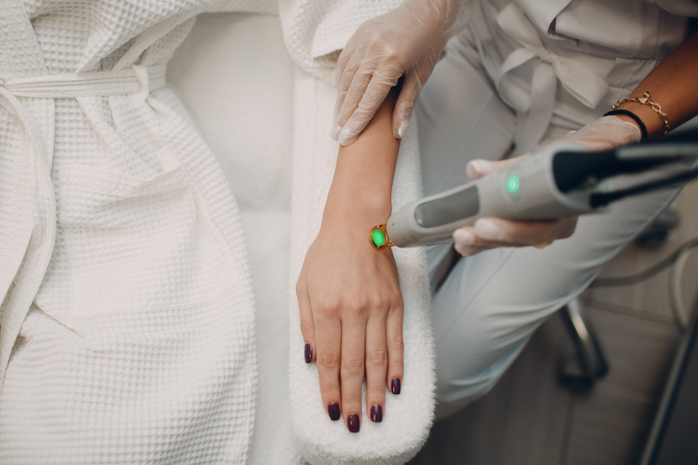 une therapeute qui effectue une epilation laser sur les mains d'une femme à la peau claire 